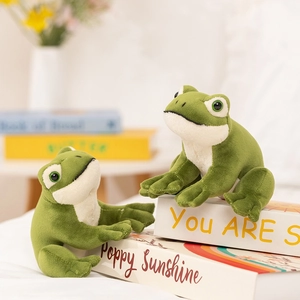 Set of two cute green sitting frog plush toys with soft fur in a home lifestyle setting