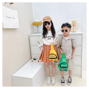 Kids school bus crossbody bag in yellow and green worn by two children at home