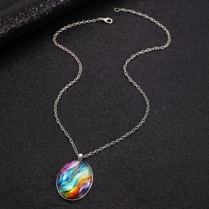 Close-up of a silver chain necklace featuring an oval pendant with colorful fluid art pattern