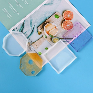 Close-up of square and octagonal silicone resin molds with finished glitter coasters