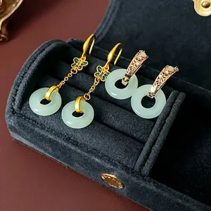 Boucles d'oreilles papillon en or avec jade vert sur une boîte à bijoux en velours