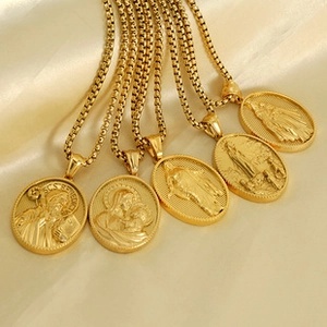 Detail of 18K gold plated religious medallions on soft champagne satin fabric