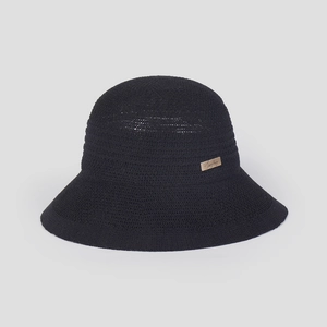 Detail of black knit sun hat featuring breathable texture and a gold metal logo tag
