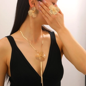 Detail of elegant gold flower jewelry set with textured petals and tassel necklace