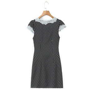 Détail d'une robe rétro à pois avec des finitions en dentelle blanche au col et manches