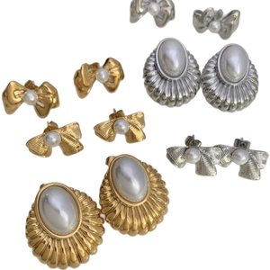 Elegant pearl bow earrings set in gold and silver finish with vintage shell texture
