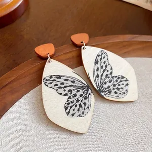 Leaf-shaped wooden drop earrings with butterfly wing pattern and silver needles