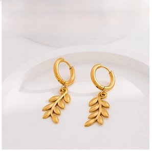 Detail of gold wheat ear dangle hoop earrings featuring textured leaf charms and polished finish