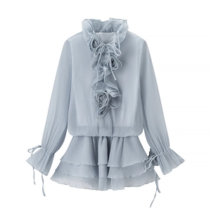 Close-up of light blue pleated chiffon top featuring delicate 3D rose and ruffle details