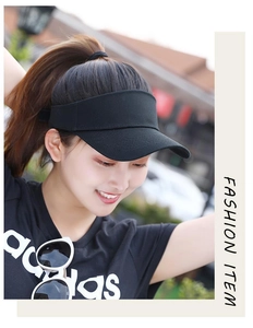 Detail of black sun visor cap with open top design shown on a model in sunlight