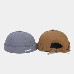 Detail of adjustable metal buckle and fish embroidery on cotton docker hats