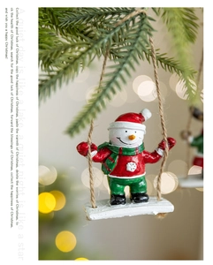 Close-up of a festive resin snowman on a white swing for Christmas tree decoration