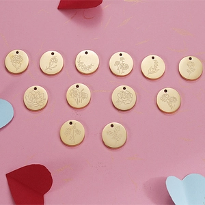 Set of 12 golden birthday flower charms with floral engravings on pink background