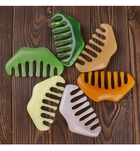 Flat lay of six wide-tooth massage combs in various colors on a dark wooden background