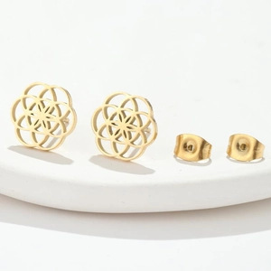 Elegant gold hollow geometric flower stud earrings with butterfly backings on a white stand