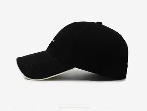 Detail view of black cotton baseball cap with white side embroidery and cream brim piping