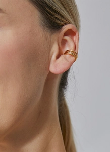 Detailed view of layered gold ear cuffs on a model for a minimalist geometric look