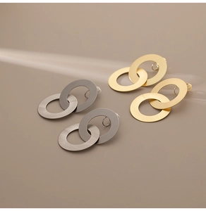 Gros plan de boucles d'oreilles géométriques en métal avec une texture brossée