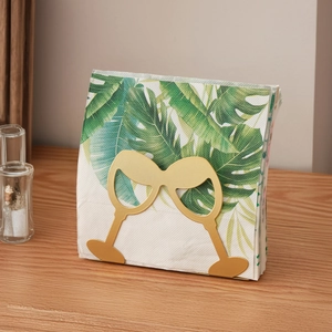 Nordic gold iron napkin holder with wine glass design on a wooden dining table