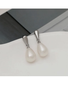 Macro shot of silver teardrop pearl earrings featuring polished metallic luster and texture