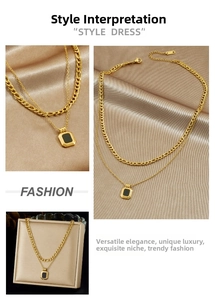 Detail of double-layer gold necklace featuring a black rectangular pendant and Cuban chain