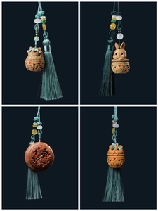 Carved sandalwood pendant featuring hollow rabbit and cat shapes with silk tassels