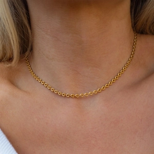 Dettaglio della collana a maglie a cuore cavo placcata oro 18 carati indossata da modella