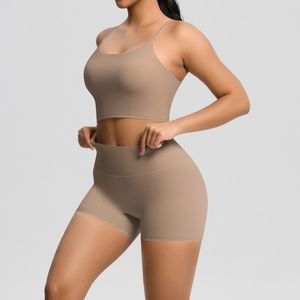 Elastic high-waisted yoga shorts and thin strap sports bra set shown on a model