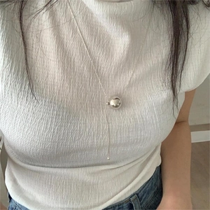 Close-up of minimalist silver beaded adjustable necklace worn by a female model