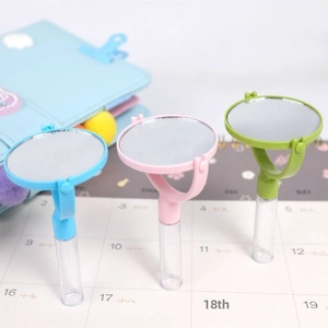 Close-up of portable round plastic mirrors in blue, pink, and green for stationery