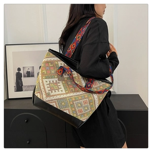 Detail of ethnic tote bag showing woven geometric pattern and colored shoulder strap