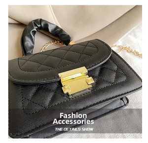 Detalle del bolso de cuero acolchado negro con asa fruncida y correa de cadena dorada