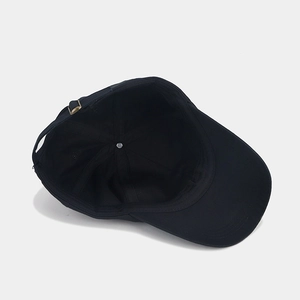 Detail of black Be Kind baseball cap showing internal stitching and adjustable metal buckle