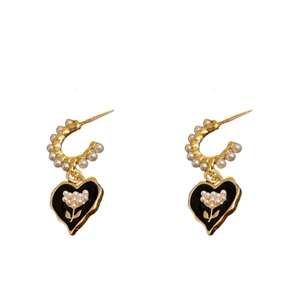 Golden heart earrings with pearls and floral details on a clean white background