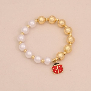 Detailed close-up of a pearl bead bracelet featuring a red ladybug insect charm pendant