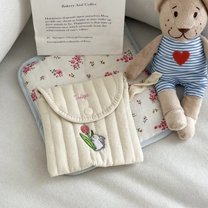 Close-up of a quilted cotton pouch with cute tulip and rabbit embroidery and snap button