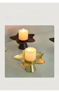 Detail of star-shaped metal candle holder with golden hammered finish and matte brown texture