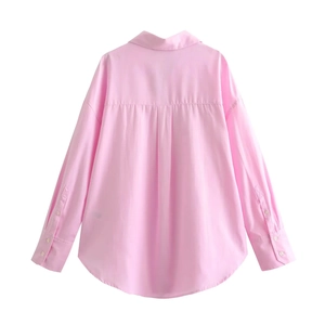 Detail view of pink Oxford shirt featuring back pleat design and curved hem for women