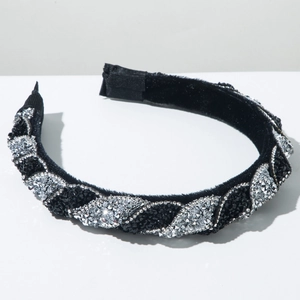 Dettaglio del cerchietto intrecciato in velluto nero con brillanti strass di cristallo