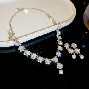 Detail view of pearl and rhinestone flower jewelry set with necklace and earrings