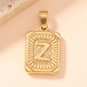 Detailed macro view of gold-plated square pendant with embossed letter Z and coin-style edges