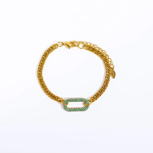 Macro shot of gold Cuban chain link choker with a rectangular green zircon pendant