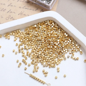 Macro shot of 14k gold-plated tiny cube beads for DIY jewelry making and bracelet crafts