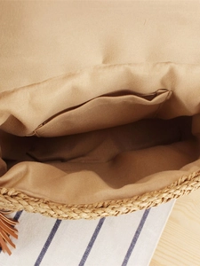 Minimalist straw woven crossbody bag with interior fabric lining and brown tassel detail