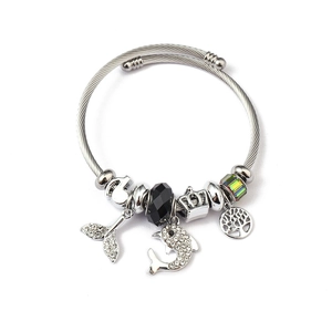 Silver charm bracelet with dolphin, tree of life, and crystal pendants on white background