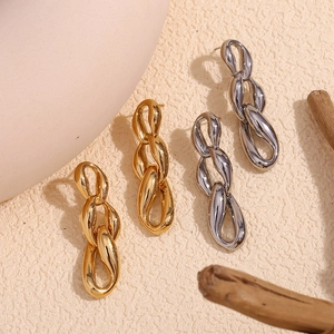 Detail shot of triple interlocking link earrings in polished gold and silver finishes