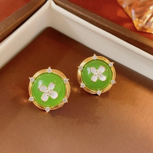 Détails de boucles d'oreilles vintage vert émeraude avec motif floral et cadre doré