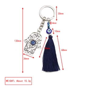 Detailed view of Hamsa Hand and Evil Eye keychain with size measurements and blue tassel