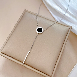 Macro shot of silver titanium steel Roman numeral ring pendant with a vertical bar charm