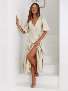 Detail of elegant V-neck puff sleeve maxi dress with high side slit in beige linen